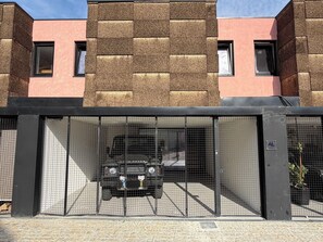 Un edificio moderno con fachada de ladrillo y entrada protegida por un portón.