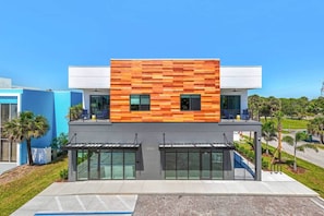 Un bâtiment moderne doté d’une façade en bois, de grandes fenêtres et d’un toit plat.
