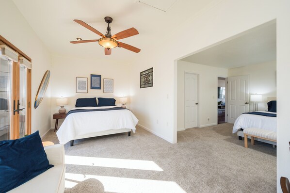 A bedroom with a bed, a ceiling fan, a nightstand, a lamp, and a window. - Steps to Beach: Fire Pit, Surfing & Dunes Access. Perfect for two couples! (Oceano)