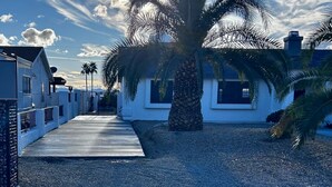 A residential street with a palm tree, white houses, and a clear sky. - The Maverick Sunset Escape (Lake Havasu City)