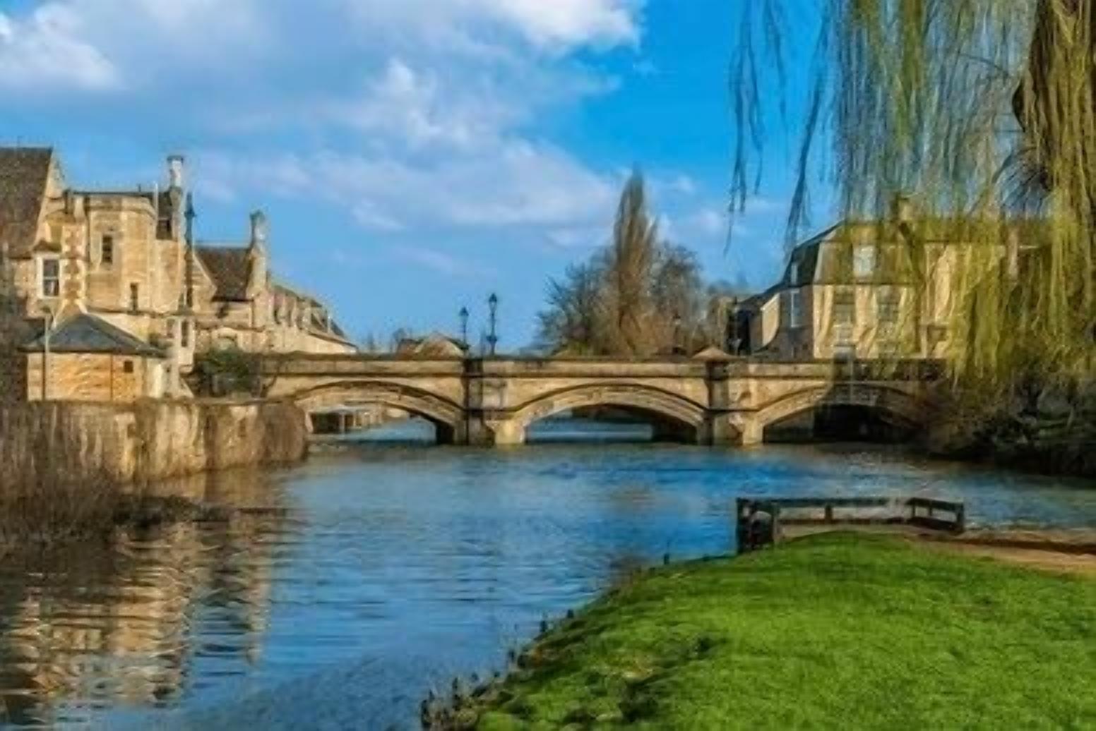A stone bridge over a river with buildings on either side.