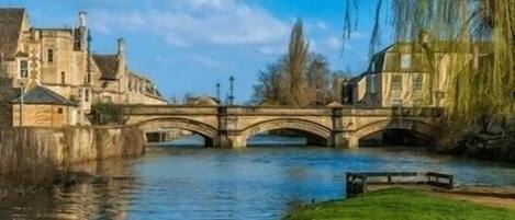 A stone bridge over a river with buildings on either side.