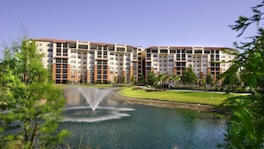 A hotel with multiple floors, a central courtyard with a fountain, and surrounding greenery.