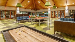 Un área de recreación con mesa de billar, asientos y mesa de juego de discos.