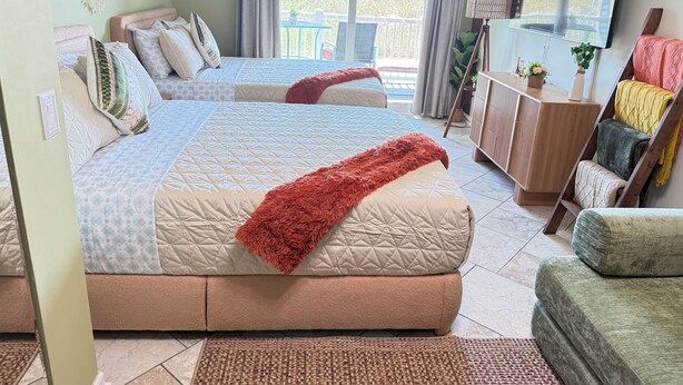 A well-lit bedroom with two beds, a large window, and a view of the outdoors. - Beautiful serenity place (North Myrtle Beach)