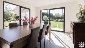 A modern kitchen with a large island, sliding glass doors, and a view of the backyard.