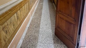 A hallway with a marble floor, wooden paneling, and a large wooden door. - Marini Palace (Spoleto)