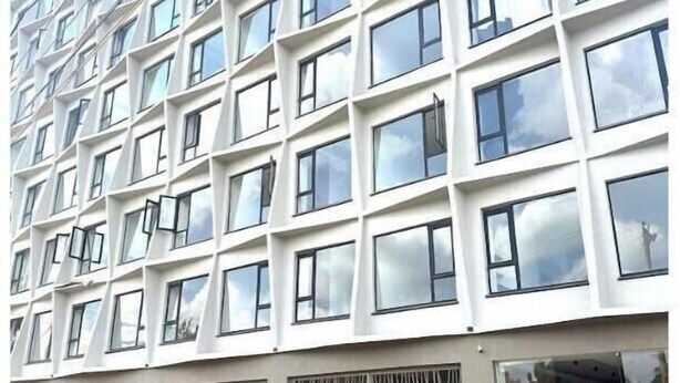 Un edificio de varios pisos con una fachada plana y una cuadrícula de ventanas.
