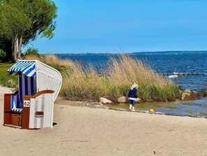 A beachside location with a beach chair numbered 62, a sandy beach, and a view of the sea. - New dream country home on the edge of the forest & a 20-minute walk from Mönkebude Sandy Beach! (Mönkebude)