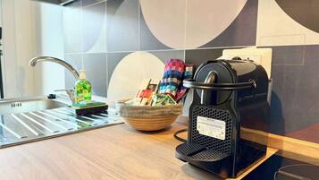 A modern kitchen with a coffee machine, a bowl of snacks, and a bottle of dish soap on the counter.