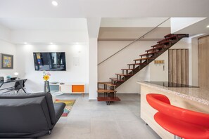Dúplex superior, balcón, vista a la ciudad | Área de sala de estar