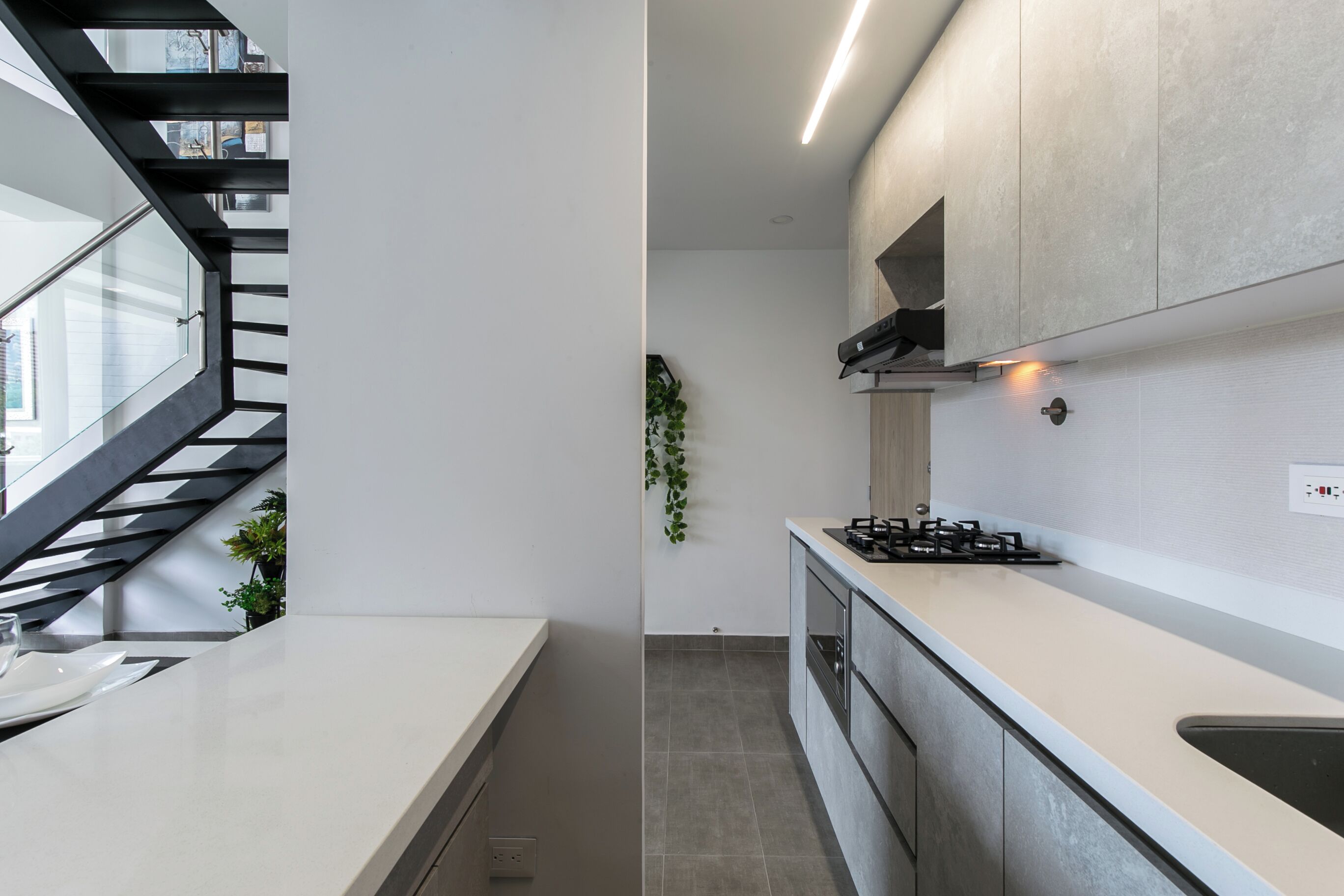 Een moderne keuken met een centraal eiland, een ingebouwde kookplaat en een strak aanrecht.