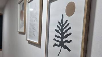 Trois œuvres d’art encadrées sont accrochées au mur.