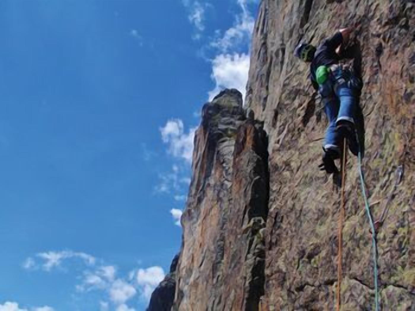 Una persona che scala una parete rocciosa.
