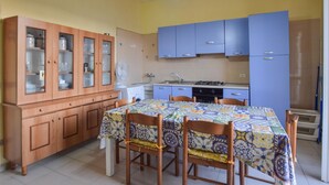 Una cocina con mesa, sillas, armarios y un lavamanos.