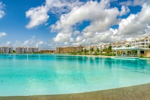 A resort with a large pool, multiple hotel buildings, and a clear blue sky. - Peace on The Beach in Punta Cana (Punta Cana)