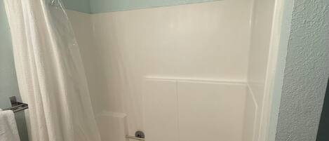 Ein Badezimmer mit einer Badewanne, einer Dusche und einem Vorhang.