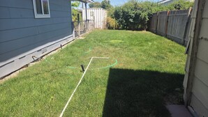 A backyard with a lawn, a hose, and a wooden fence. - Lovely family and  pet friendly townhome in charming Fruitland Idaho (Fruitland)