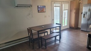 A kitchen with a dining table, chairs, a refrigerator, and a window with blinds. - Lovely family and  pet friendly townhome in charming Fruitland Idaho (Fruitland)