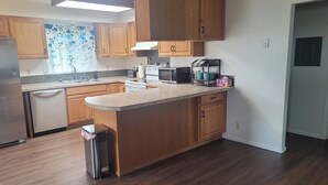 A kitchen with wooden cabinets, a stainless steel refrigerator, a dishwasher, a microwave, and a coffee maker. - Lovely family and  pet friendly townhome in charming Fruitland Idaho (Fruitland)