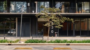 A modern building with a balcony, large windows, and a tree in the foreground. - MYLA - Loft - Chapultepec HighF (Mexico City)