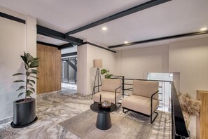 A modern living area with a sofa, a coffee table, and a potted plant. - Myla - 01C Roma Norte - LowF (Mexico City)