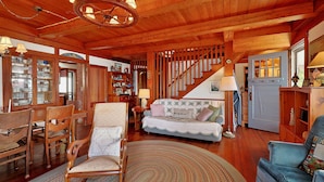 A wooden interior with a sofa, chairs, and a dining area. - Quiet Oceanfront Cottage with Dock (Boothbay Harbor)