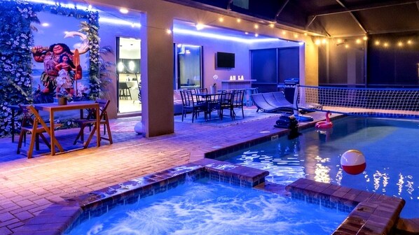 Une piscine intérieure dotée d’un jacuzzi, d’un espace détente et d’une décoration sur le thème des îles tropicales.