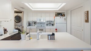 A modern kitchen with white cabinets, a central island, a built-in oven, and a microwave. - Spacious and quiet 2-bedroom casita with view in Fountain Hills (Fountain Hills)
