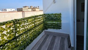 A small balcony with a wooden floor and a green plant wall. - Studio downtown Rabat terrace (Rabat)