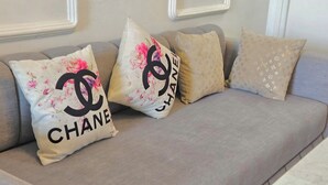 A sofa with three decorative pillows, one featuring the Chanel logo. - Studio downtown Rabat terrace (Rabat)