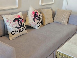 A sofa with three decorative pillows, one featuring the Chanel logo. - Studio downtown Rabat terrace (Rabat)