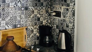 A kitchen with patterned tiles, a stove, a coffee maker, and a Moroccan tagine. - Studio downtown Rabat terrace (Rabat)