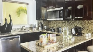 A modern kitchen with granite countertops, a built-in microwave, and a coffee machine. -  Available Dec 20-27th Christmas in the Sun 2bdrm 3 bath Luxury Condo In Cancun! (Cancún)