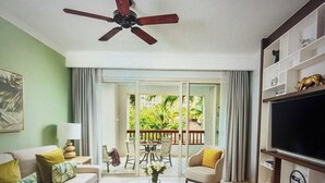 A living room with a sofa, armchairs, a coffee table, and a TV. There is a balcony with a view of greenery. -  Available Dec 20-27th Christmas in the Sun 2bdrm 3 bath Luxury Condo In Cancun! (Cancún)