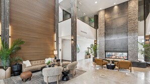 A spacious lobby with a high ceiling, a fireplace, and a modern seating area. - Luxury 2 Bedroom Condo at The Mason Pool, Free Ski Shuttle, AC (Heber City)