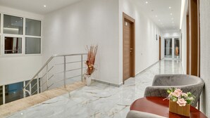 A modern hotel lobby with a marble floor, a staircase, a reception desk, and a wooden door. - Aqua Lounge Aparthotel Ulcinj (Ulcinj)