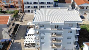 Ein mehrstöckiges Hotel mit Pool auf dem Dach und einer Außenbereich-Sitzgelegenheit.