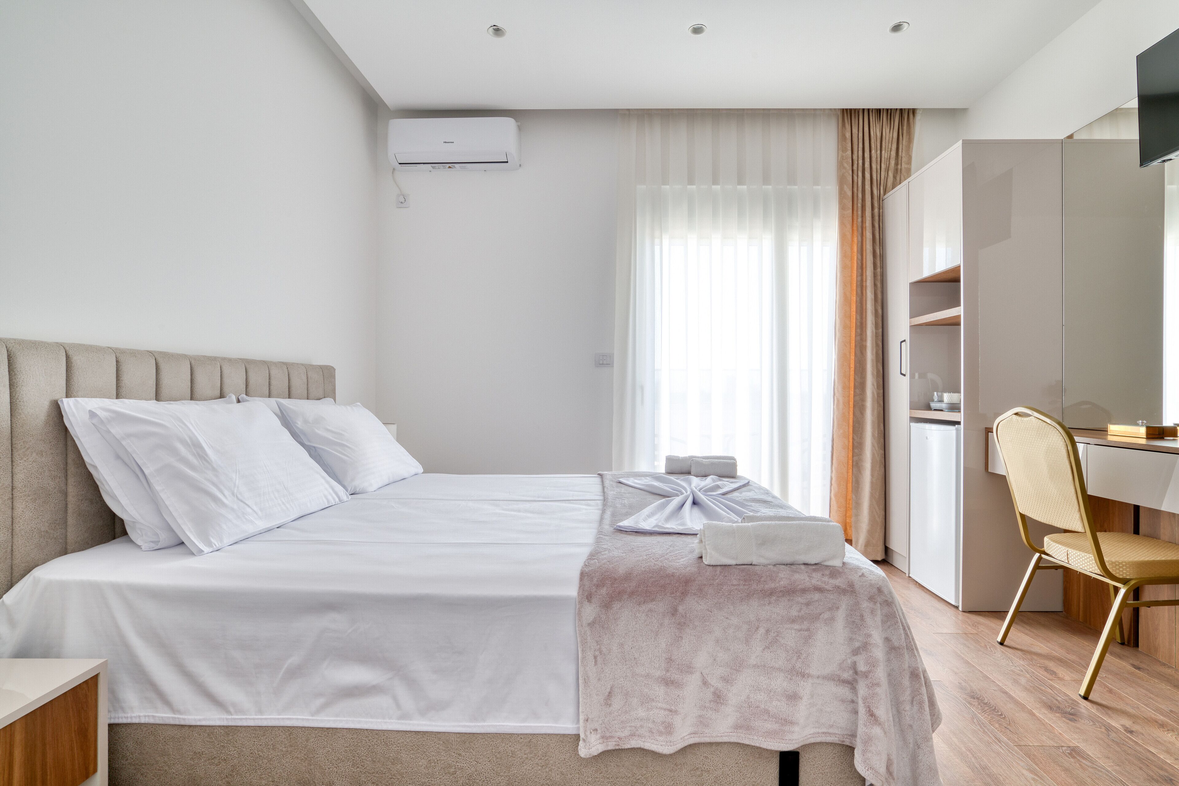 Una habitación de hotel moderna con una cama, un escritorio y una silla.