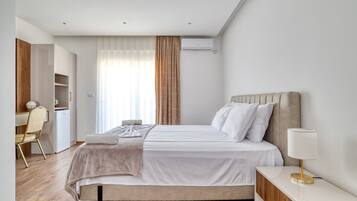 Un dormitorio moderno con cama, mesita de noche y espacio de escritorio.