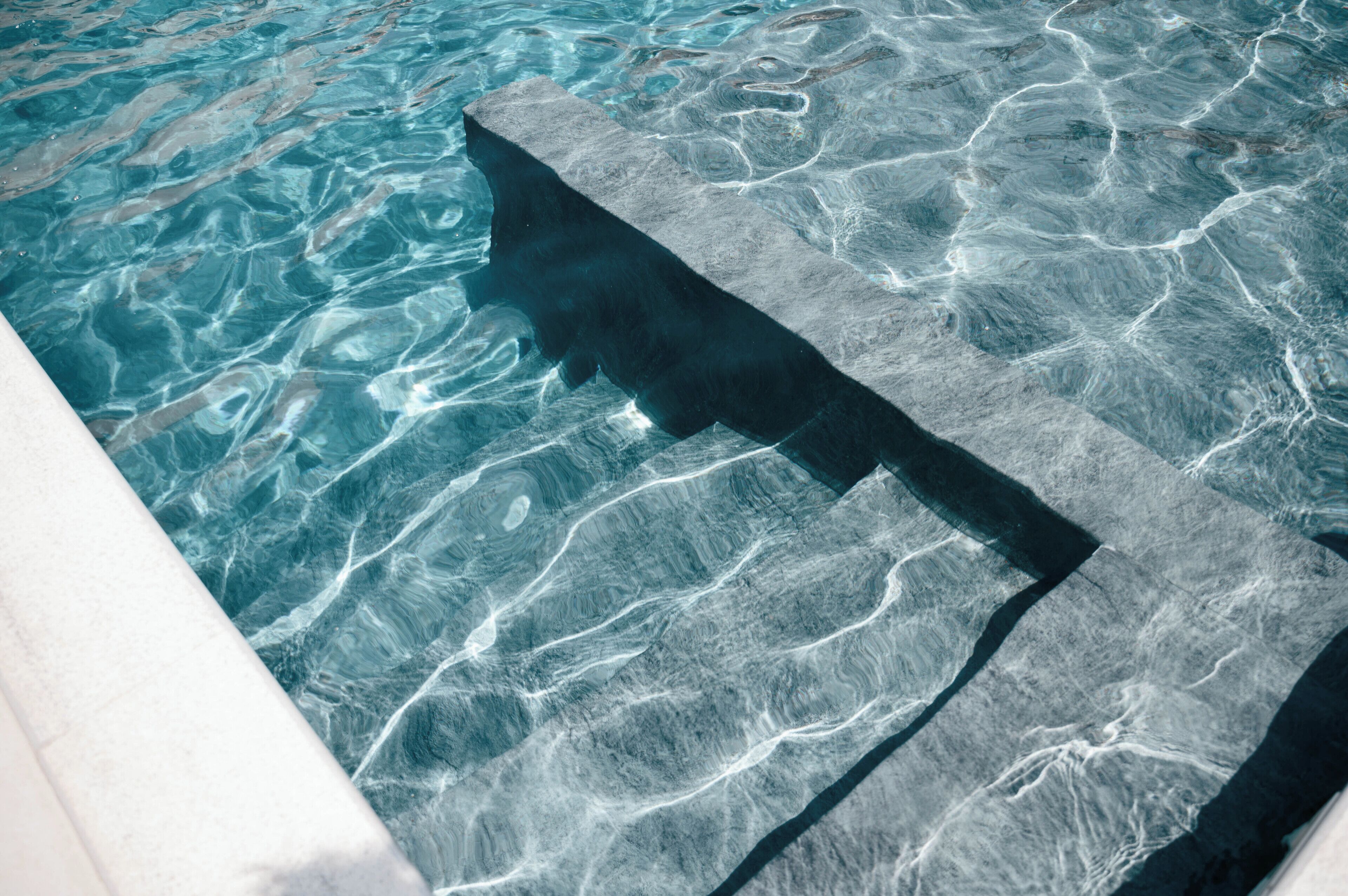 A stone pool with clear water and a stone edge.