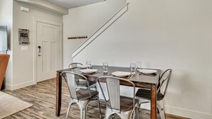 A dining area with a wooden table, metal chairs, and a staircase in the background. - Hill Field 3 by CDH in Layton (Layton)