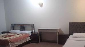 Een hotelkamer met een bed, een bureau en een nachtkastje.