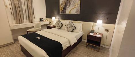 Een moderne hotelkamer met een groot bed, nachtkastjes, een bureau en een raam met gordijnen.