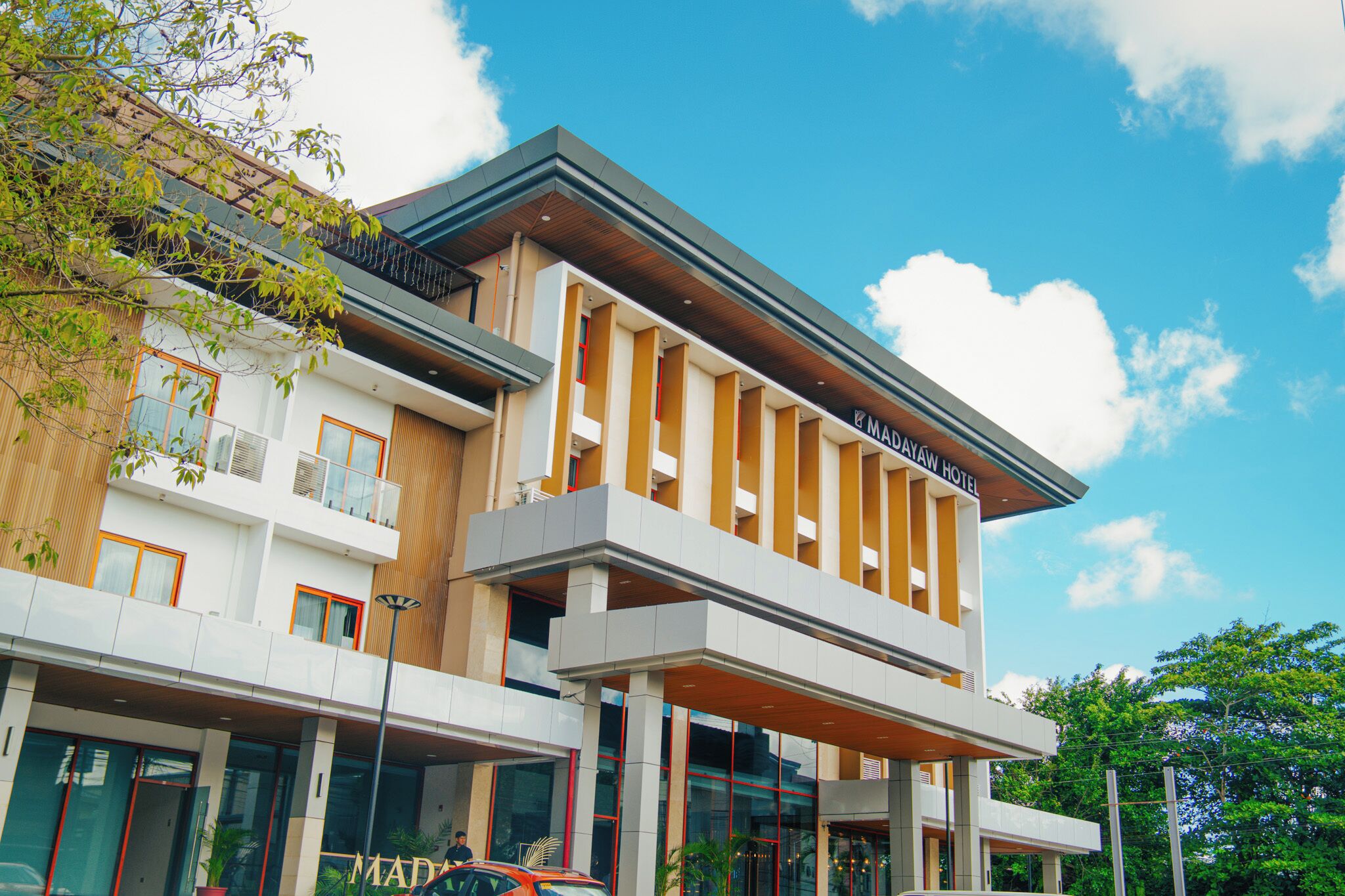 A modern hotel with a two-story structure, large windows, and a prominent sign.