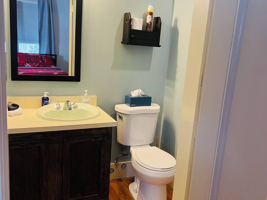 Ein Badezimmer mit Waschtisch, Waschbecken, Spiegel und Toilette.