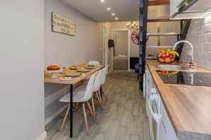 Uma cozinha moderna com área de refeições, pia e uma fruteira no balcão.
