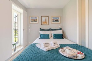 Une chambre d’hôtel avec un lit, une fenêtre et des œuvres d’art accrochées au mur.