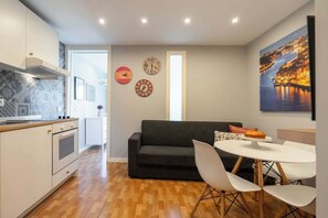 Uma cozinha moderna com área de refeições, um sofá e uma mesa com cadeiras.