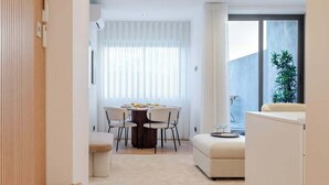 Un intérieur moderne comprenant un coin repas, un canapé et une cuisine.